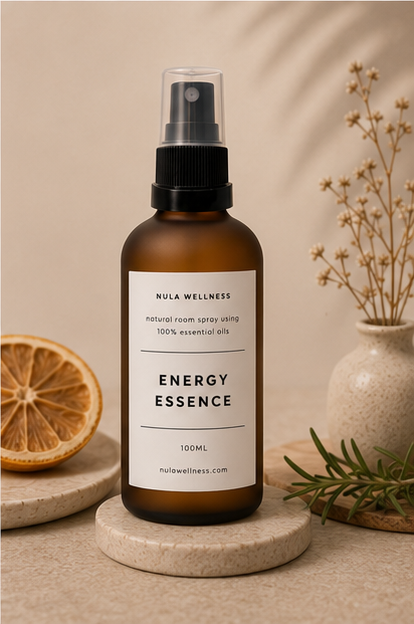 Bottle of Nula Wellness Energy Essence on a beige background with decorative elements.